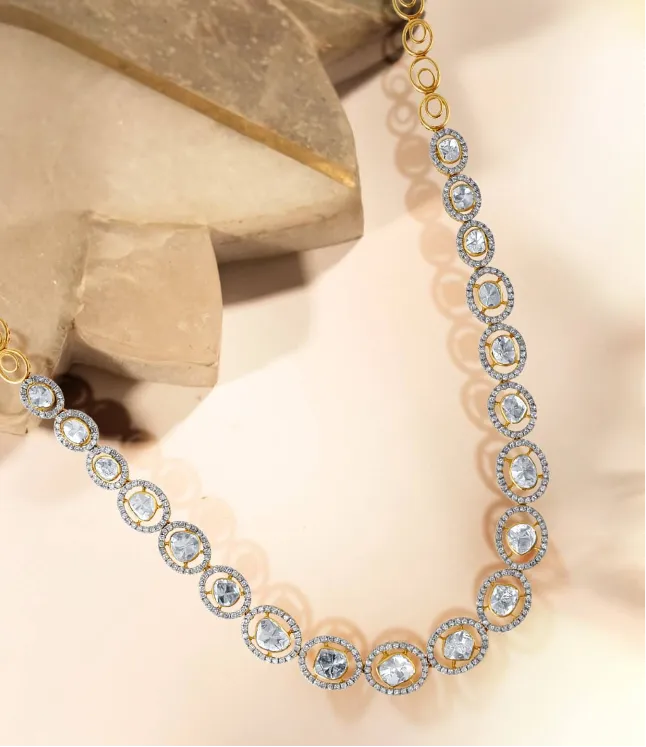 Diamond oval cluster necklace in 18kt gold laid on stone